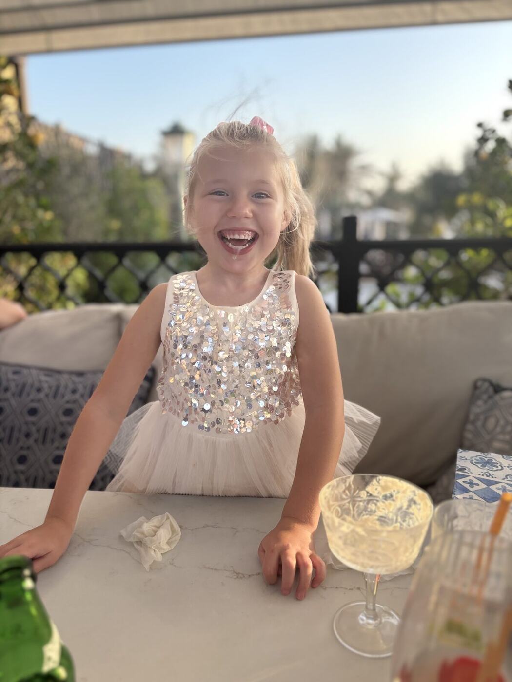 Delilah laughing at dinner in a sparkly dress